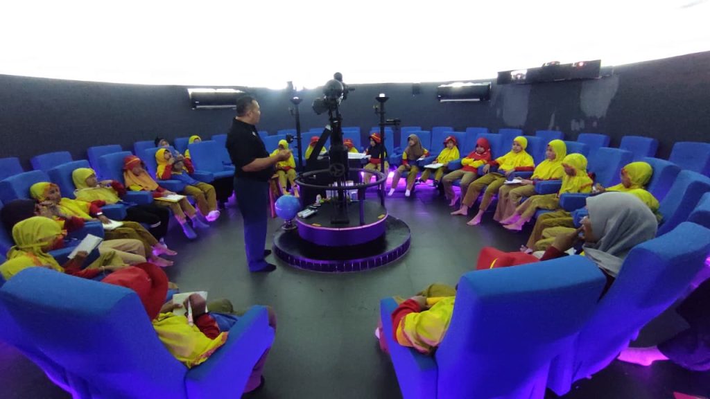 Siswi Kelas 4 Sekolah Kreatif SD Muhammadiyah 16 Surabaya di dalam Planetarium Loka Jala Crana. Mereka menyimak pemandu menjelaskan mengenari rasi bintang.